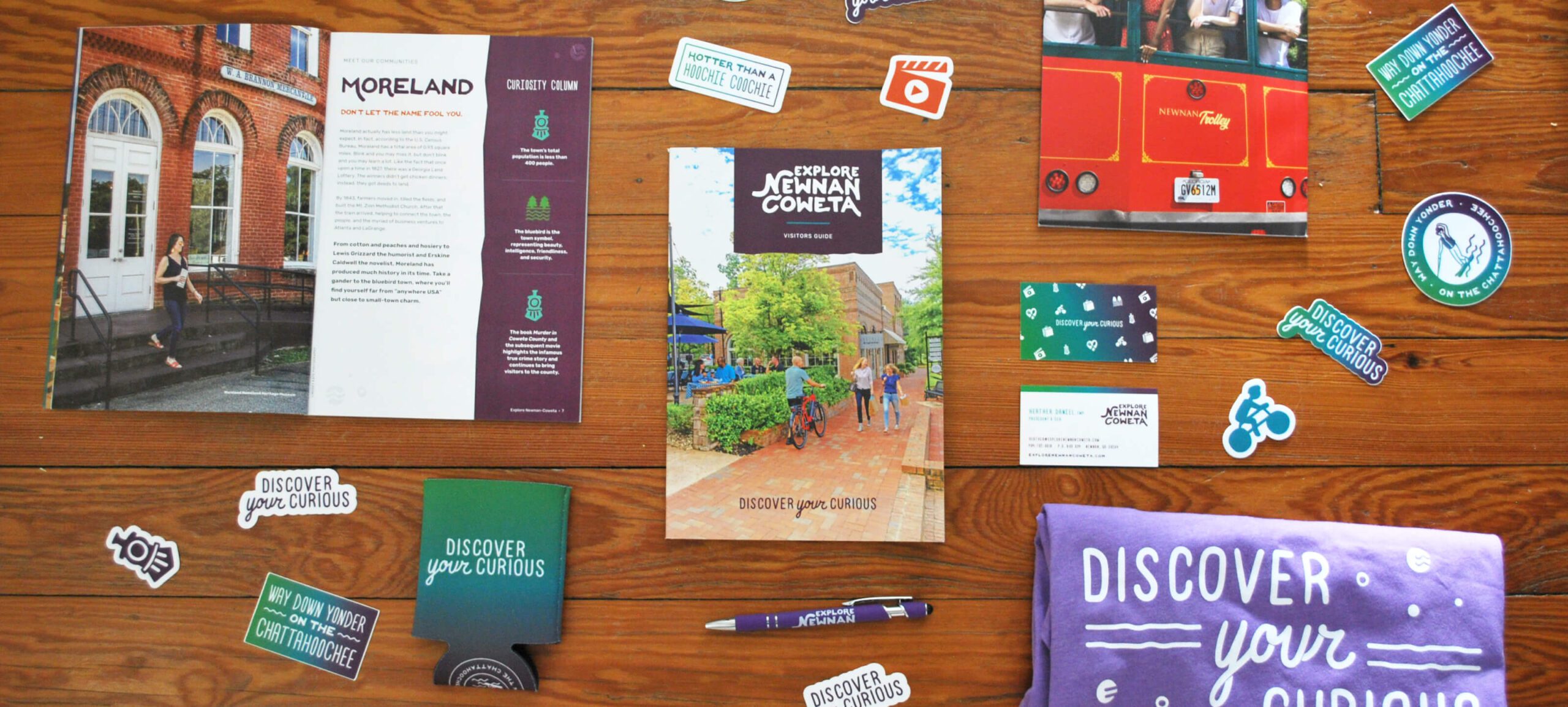 Flat lay of Newnan Coweta marketing pieces including their visitors guide, stickers, business card and more